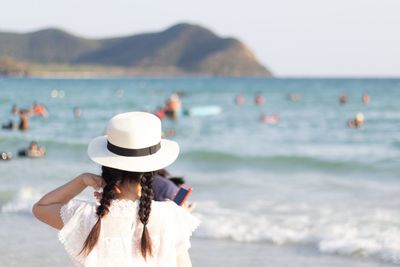 Rear view of girl standing at beach