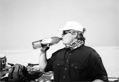 Full length of man drinking water from beach