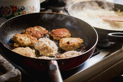 High angle view of meat in cooking pan on stove