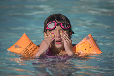 High angle view of girl swimming in pool during sunny day