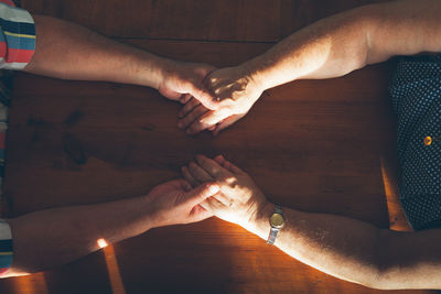 Directly above shot of couple holding hands over table
