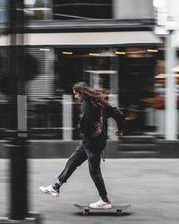 Full length of woman running on road in city