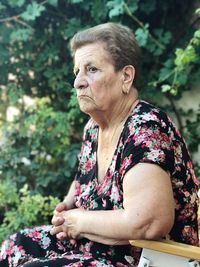 Senior woman sitting on chair in yard