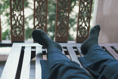 Low section of man resting on bench