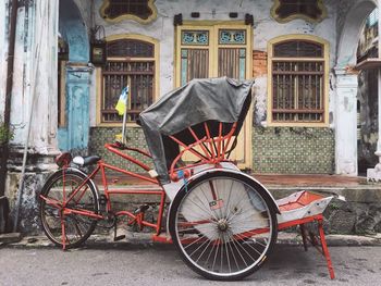 Pedicab on street against building