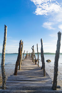 Wooden pier on sea against sky