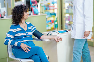 Midsection of doctor examining patient at home