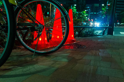 Bicycle parked on illuminated street in city at night