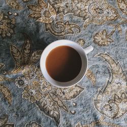 Directly above shot of tea cup on tablecloth