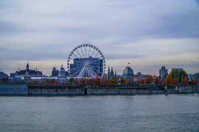 Ferris wheel by sea against sky