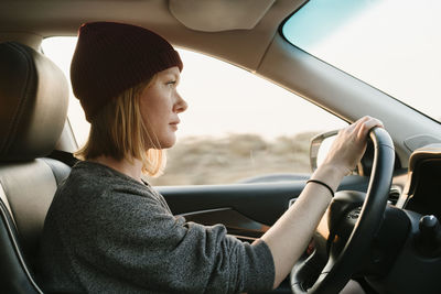 Inside view of woman driving in big sur at sunset