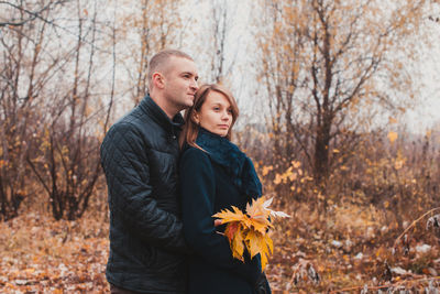 Full length of young man standing against trees during autumn