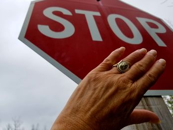 Cropped hand of woman reaching stop sign