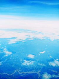 Aerial view of snowcapped landscape against blue sky