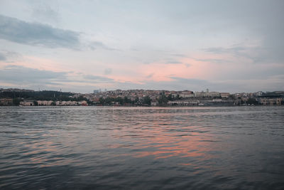 Scenic view of sea by buildings against sky