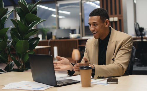 Young businesswoman using laptop at desk in office