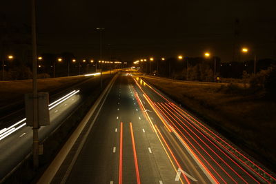 Road passing through illuminated tunnel