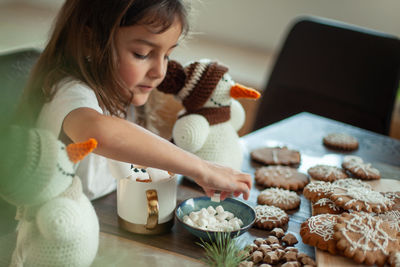 High angle view of girl looking at table