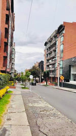 Street amidst buildings in city against sky