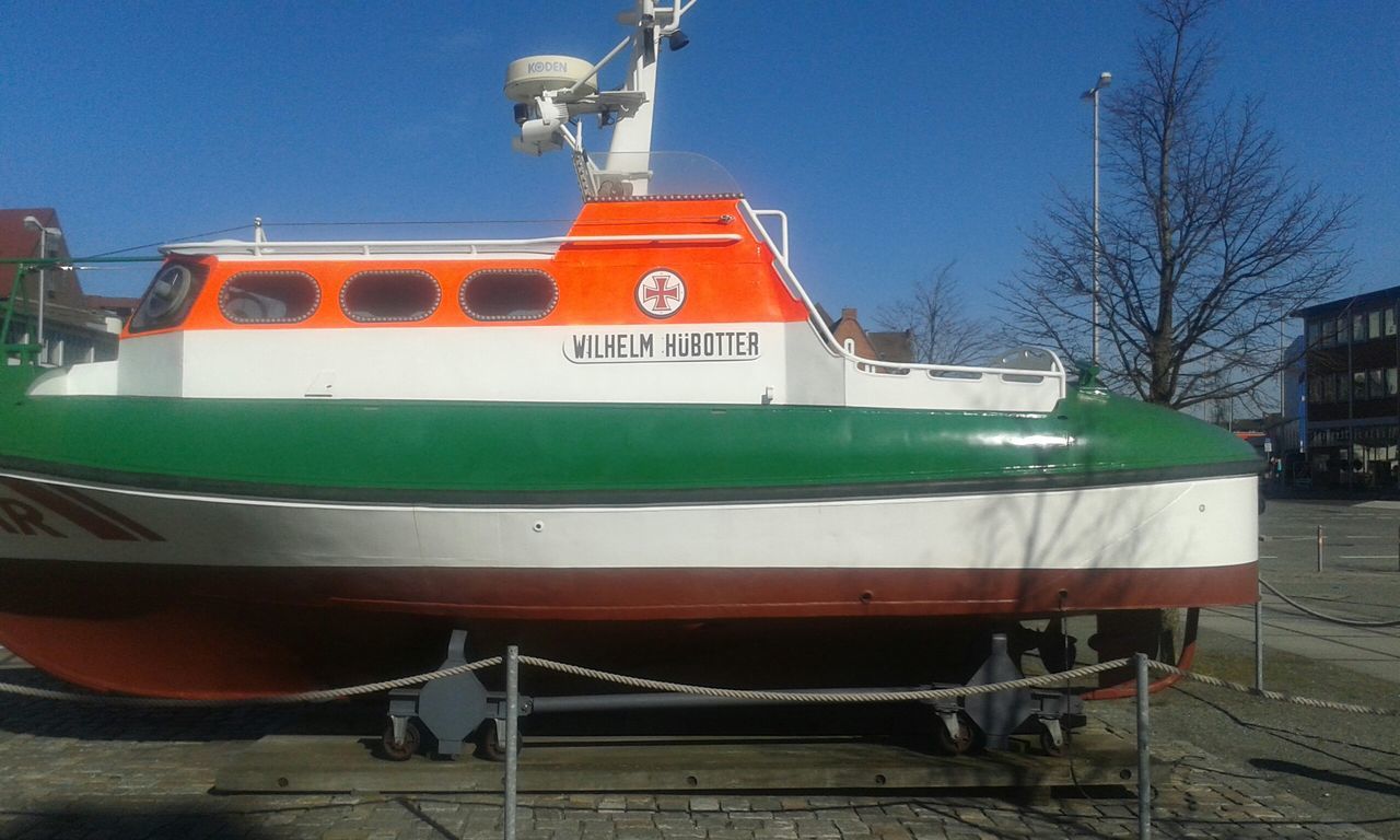 transportation, mode of transport, clear sky, railroad track, built structure, building exterior, public transportation, architecture, rail transportation, train - vehicle, nautical vessel, blue, outdoors, travel, sunlight, sky, tree, day, moored, no people