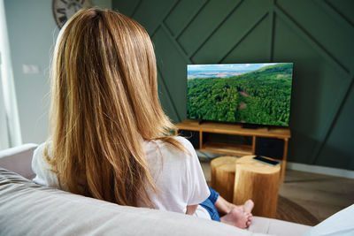 Rear view of woman relaxing at home