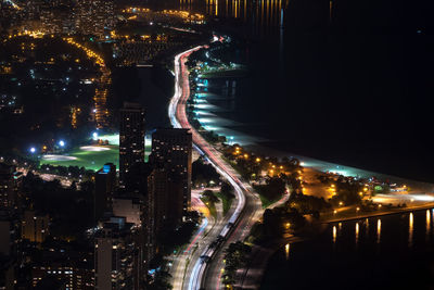 High angle view of illuminated street amidst buildings at night