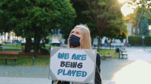 Low angle view of woman sign against trees