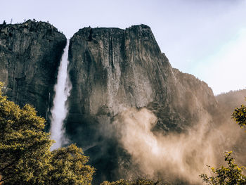 Scenic view of waterfall against sky