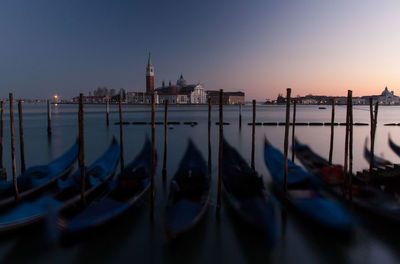 Gondolas moored on grand canal against st marks square at night