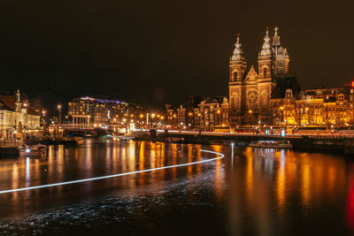 River in illuminated city at night