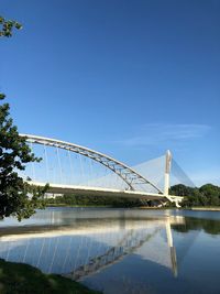 Bridge over water against clear blue sky
