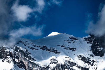 Low angle view of snowcapped mountains against sky