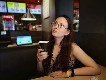 Beautiful young woman having drink in restaurant