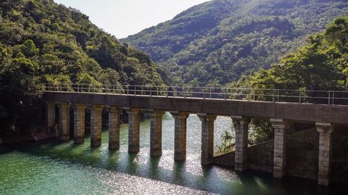 Bridge over river against mountains