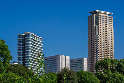 Low angle view of modern buildings against clear blue sky