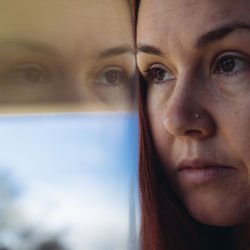 Close-up of woman reflection on glass window