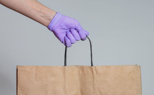 Close-up of hand holding umbrella against white background