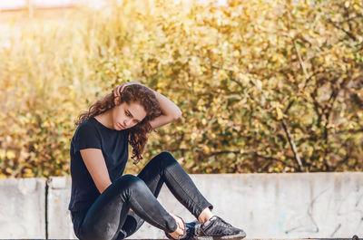 Side view of young woman exercising on field