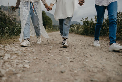 Low section of friends walking outdoors