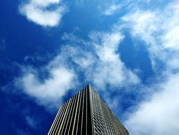 Low angle view of modern building against cloudy sky