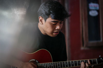 Man playing guitar at home