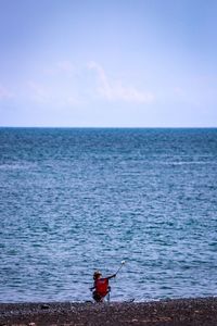 Man surfing on sea against sky