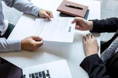 Midsection of man holding hands on table