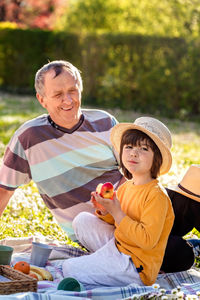 Portrait of smiling friends sitting on field