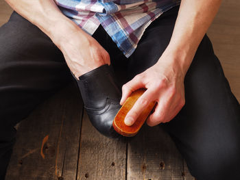 Midsection of man polishing shoe