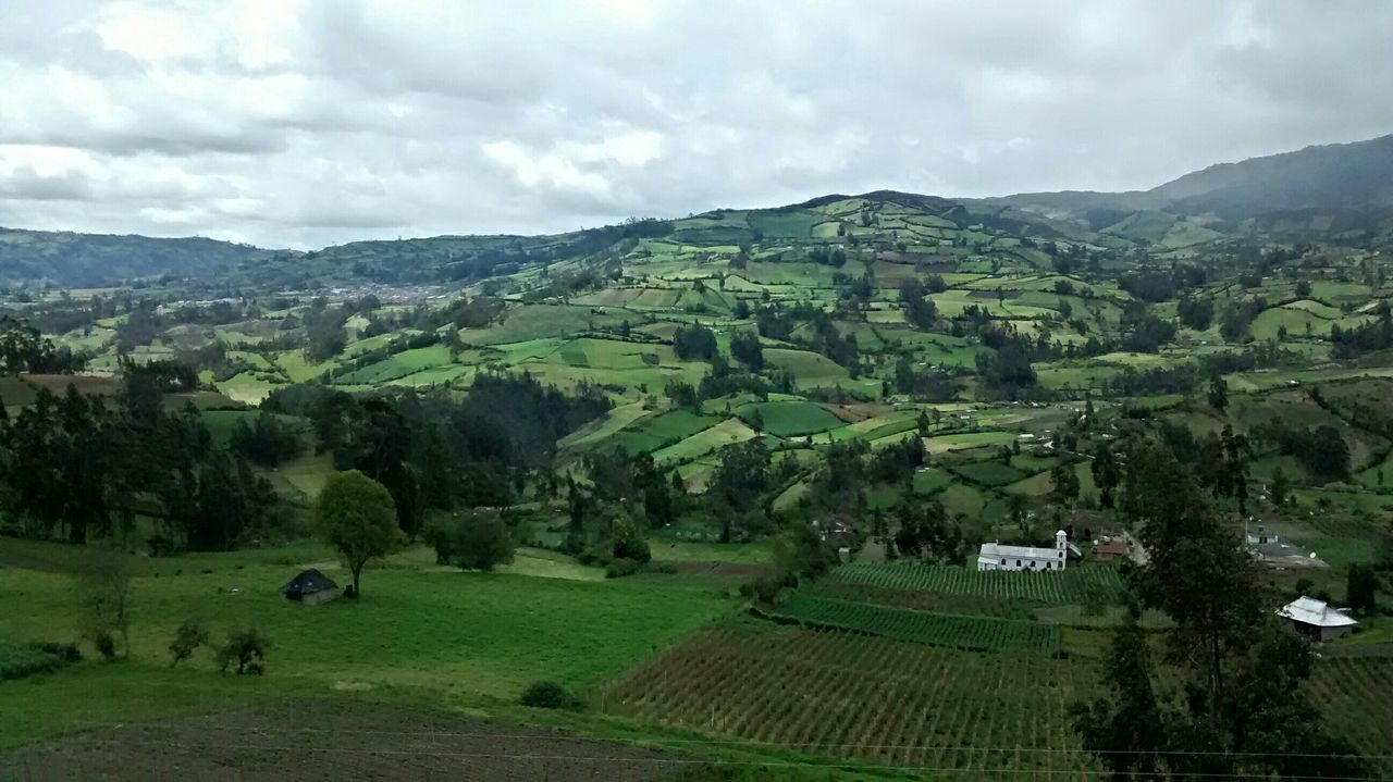 landscape, sky, green color, tranquil scene, mountain, scenics, tranquility, tree, agriculture, cloud - sky, grass, field, beauty in nature, rural scene, nature, built structure, architecture, high angle view, building exterior, cloudy