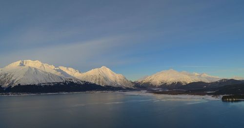 Scenic view of snowcapped mountains against blue sky