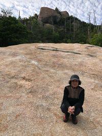 Portrait of senior woman crouching on mountain