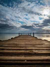 Pier on beach against sky