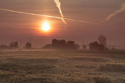 Scenic view of landscape against orange sky